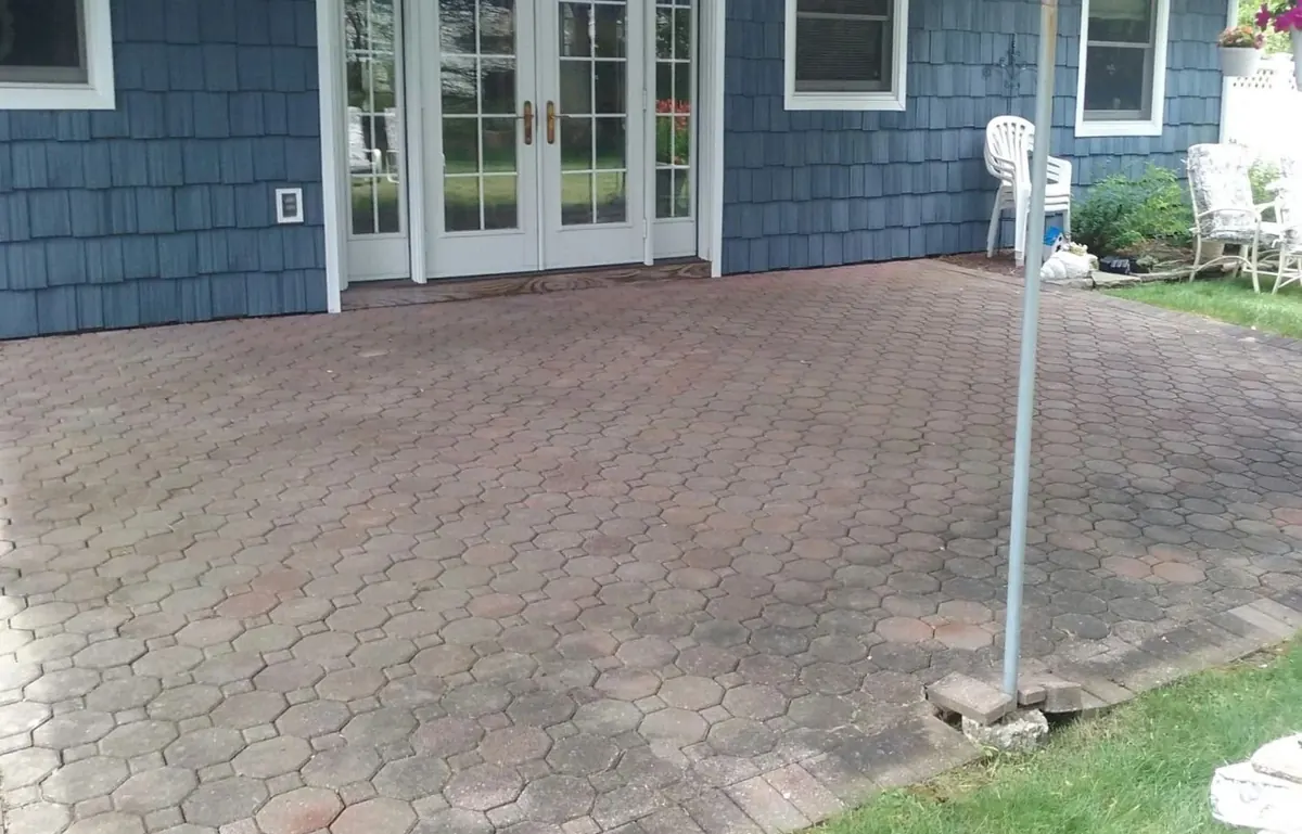 The same brick-paver patio cleaned back to red and tan brick