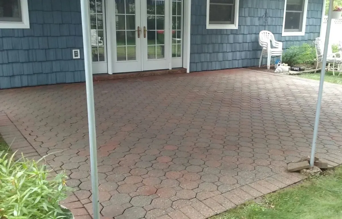 Brick-paver patio darkened with grime and algae, before cleaning